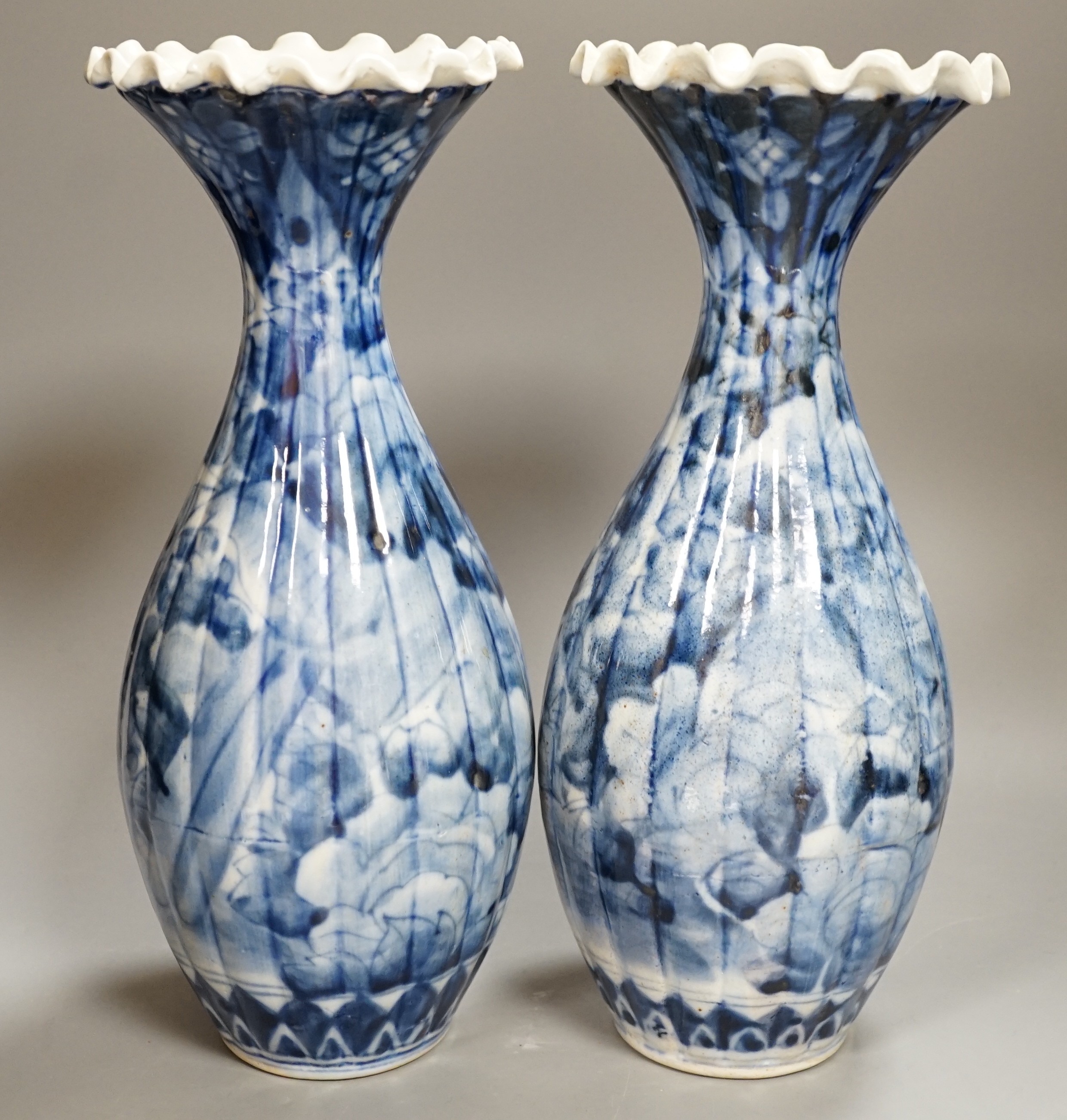 A pair of early 20th century Japanese fluted blue and white flared rim vases, 31.5cm